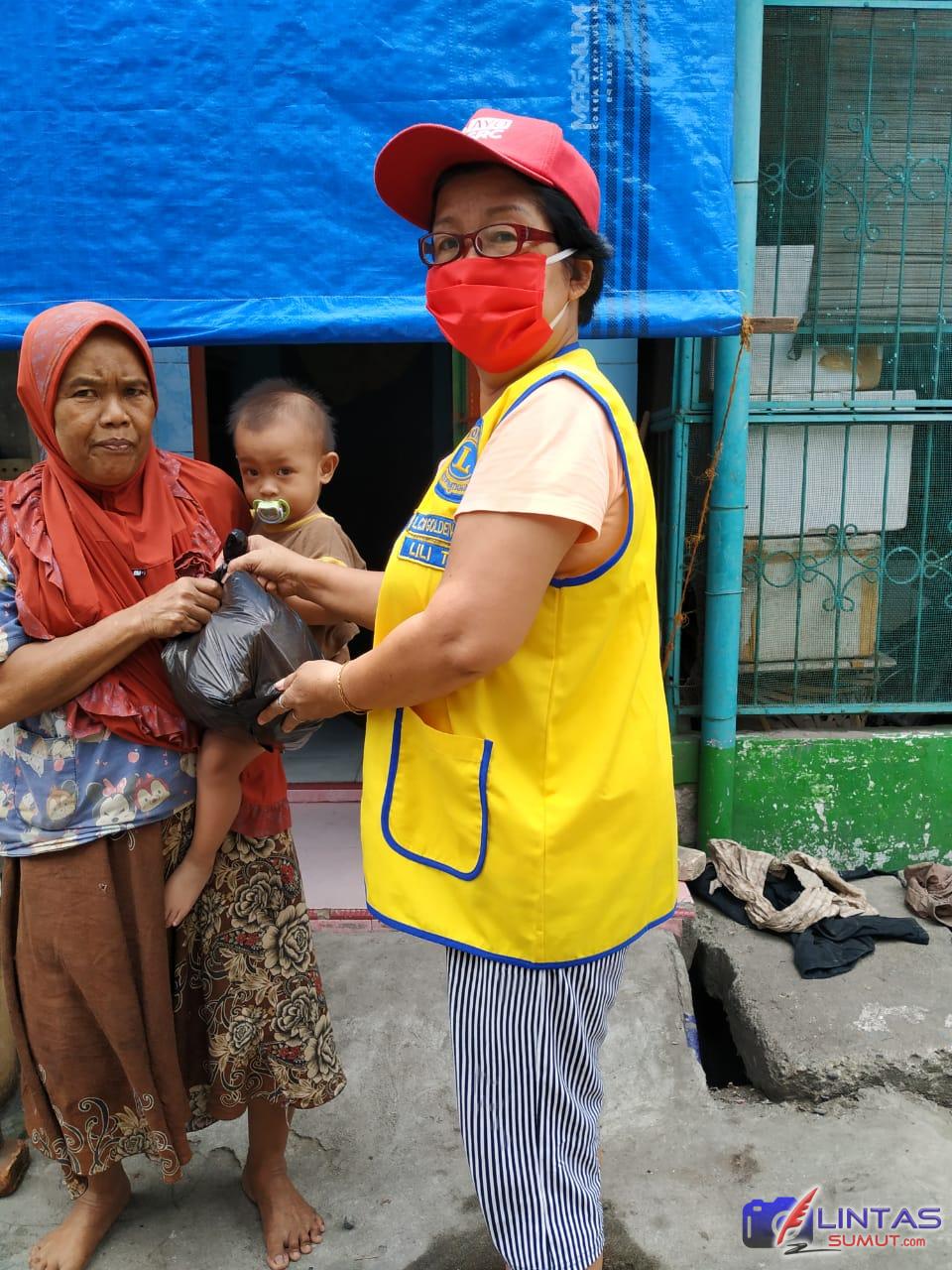 Foto:Ket// Vice President Lions Club Golden Estate Lion Lili Tan sedang membagikan sembako